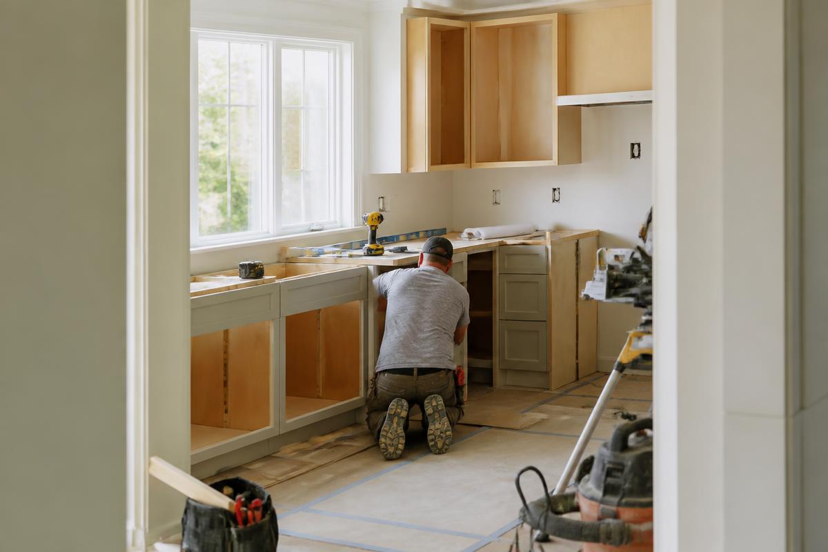 Contractor installing cabinets during a residential kitchen renovation
